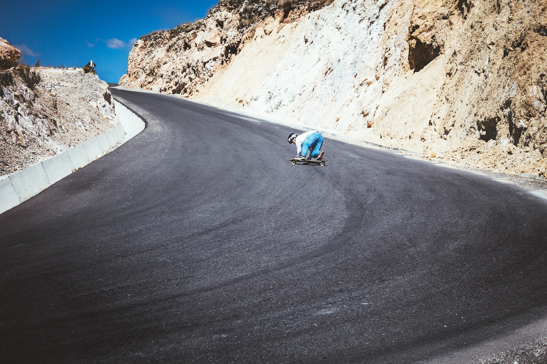 A skater cruising down a sunlit Colorado street in Bright Eye's graphic tee and worn-in jeans, with a backdrop of mountain peaks.