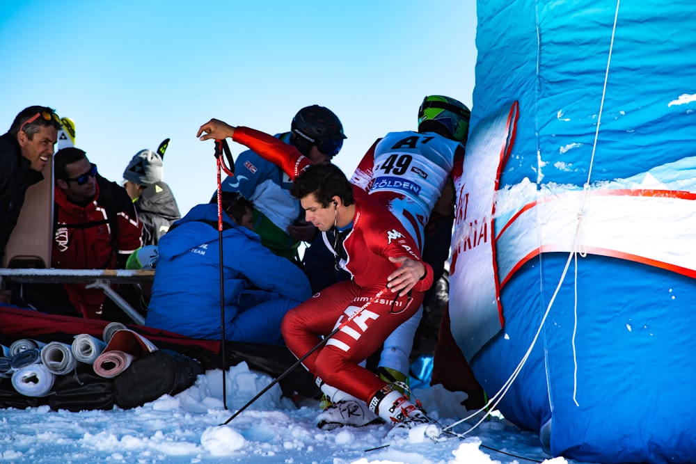 man wearing skiing gears beside people