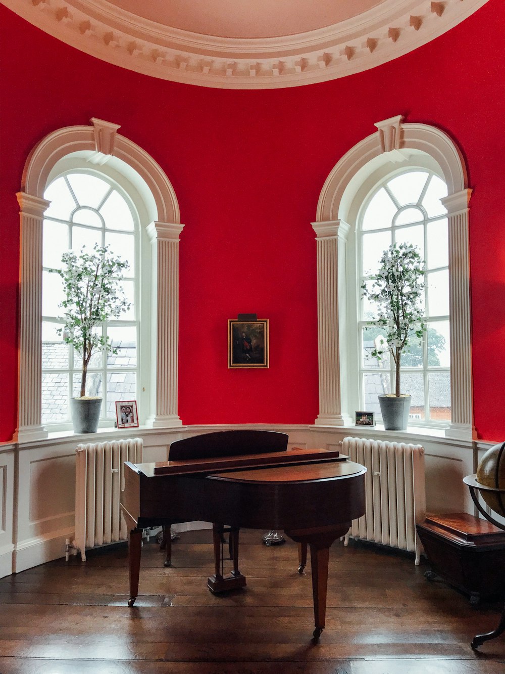 brown grand piano near windows