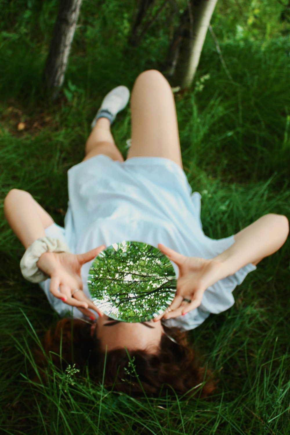 woman lying on bed holding glass ball