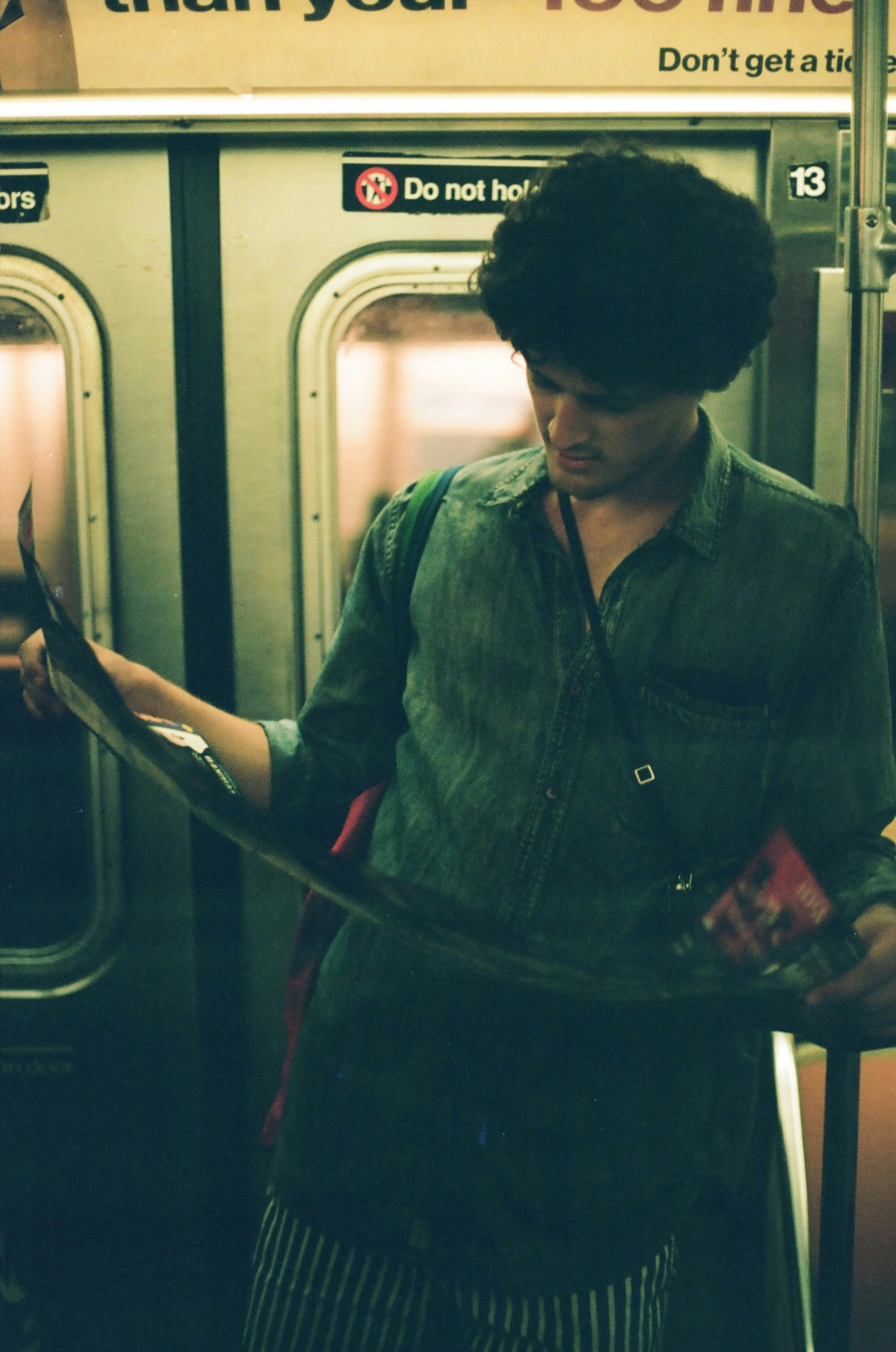 man inside train holds poster