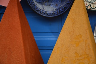A vibrant close-up of hands preparing colorful Indian spices on a rustic wooden table.