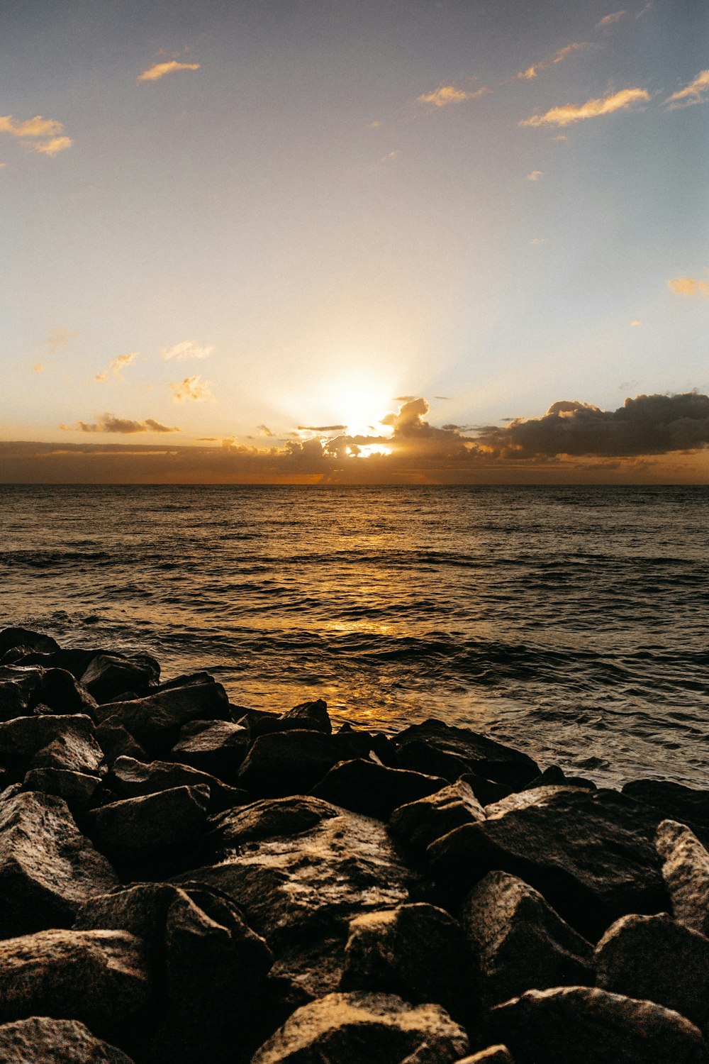 De l’eau de mer à côté des rochers pendant l’heure dorée