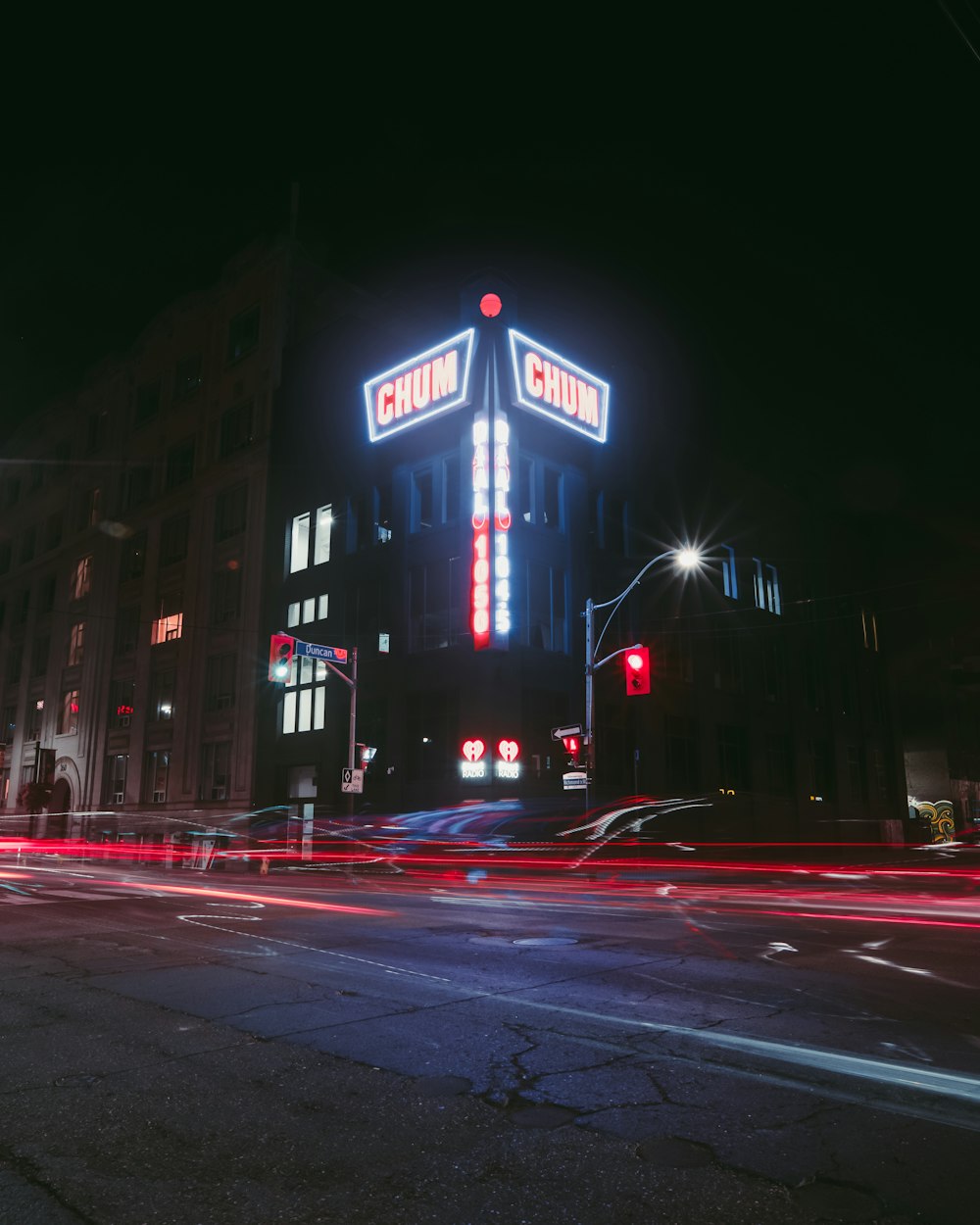 uma rua da cidade à noite com um edifício iluminado
