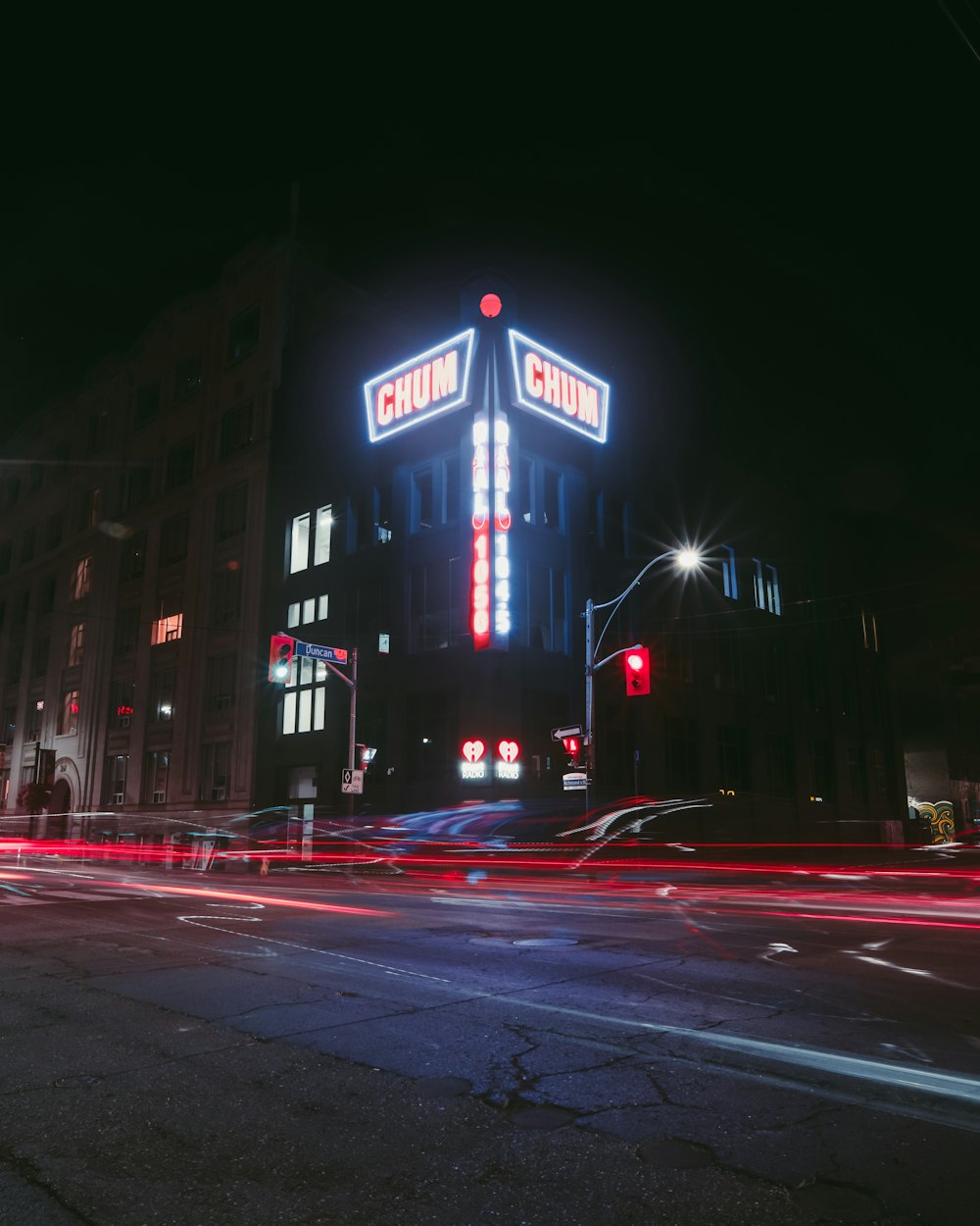 Una calle de la ciudad por la noche con un edificio iluminado