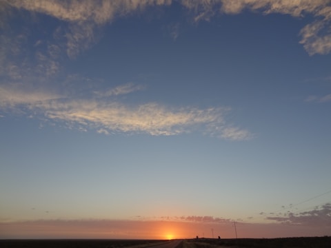 A sunrise breaking through clouds over a quiet road, symbolizing hope and new beginnings.