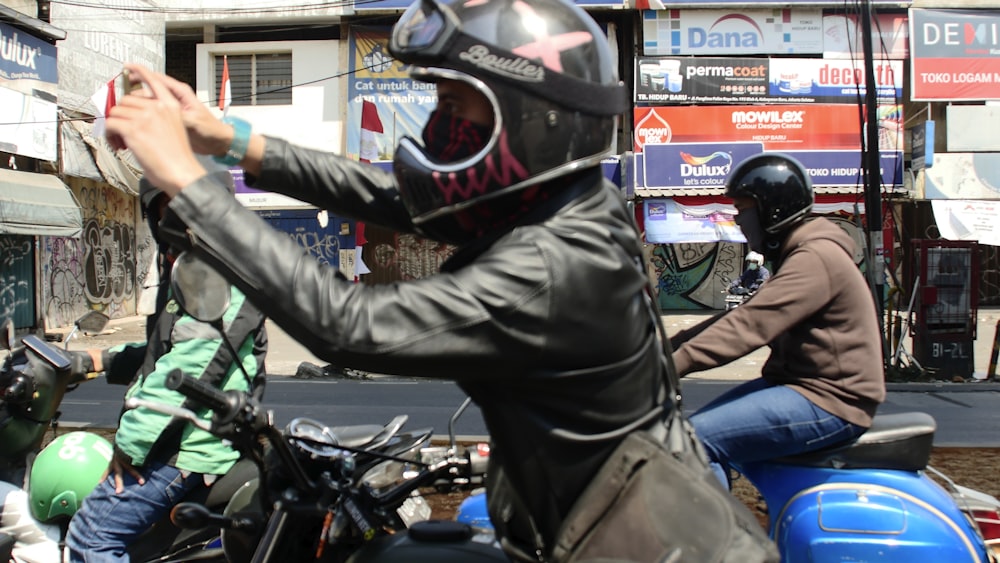 person riding motorcycle wearing black full-face motorcycle helmet