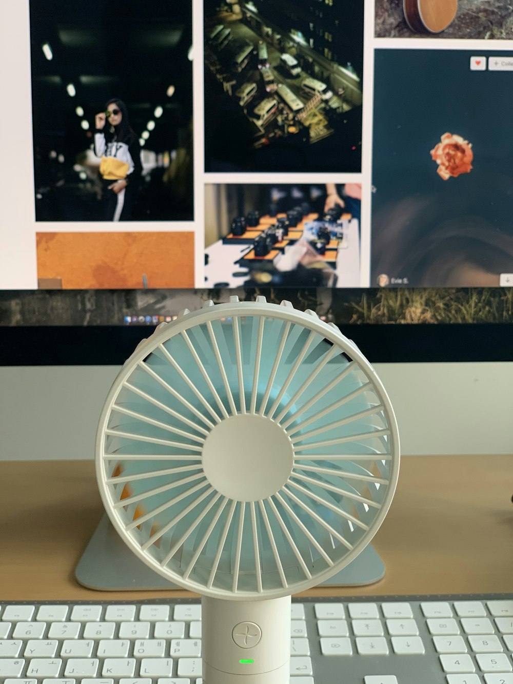 turned-on white and blue fan on table
