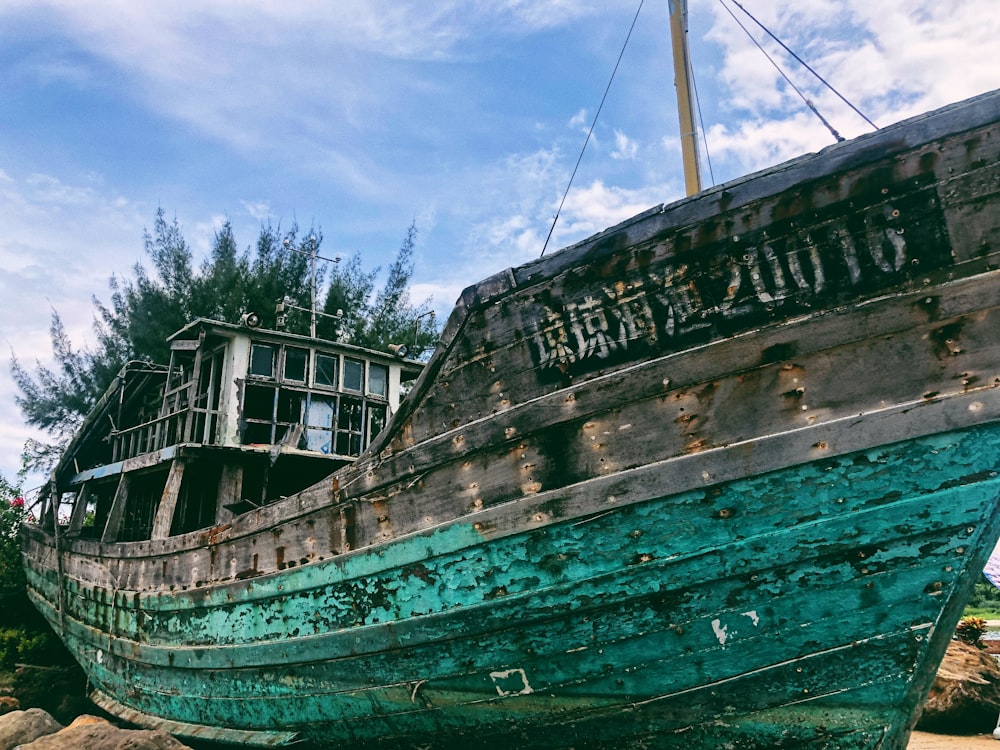 wrecked blue and gray boat at daytime