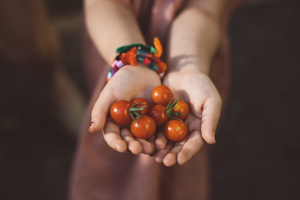 mulher com punhado de tomates cereja