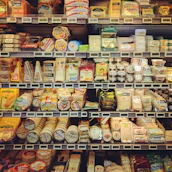 Shelves stocked with a variety of fresh dairy products and beverages in a cozy shop.
