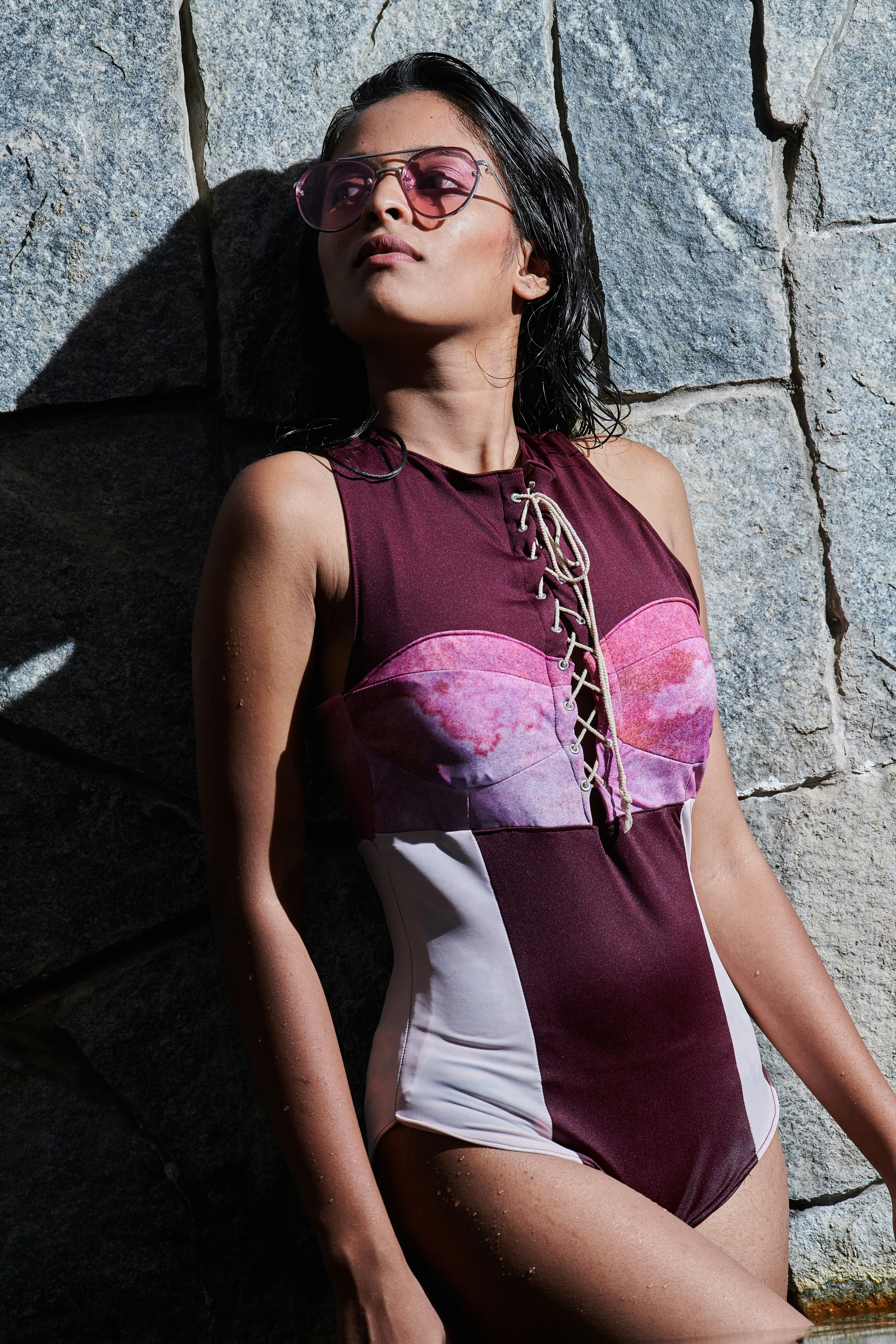 Frau trägt einteiligen Badeanzug mit Sonnenbrille