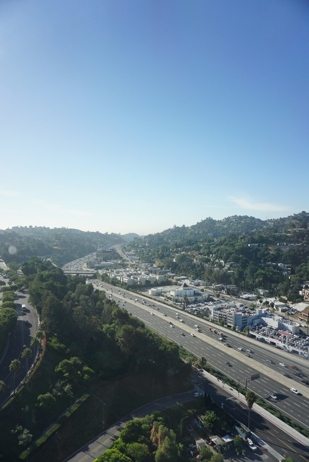 aerial photography of vehicle passing road under clear blue sky during daytime