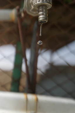 Close-up of a clean water drop falling from a high-tech water filtration unit.