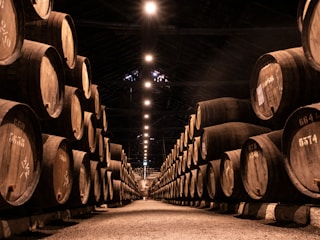 A sleek warehouse interior with stacked barrels of motor oil and lubricants under warm lighting.