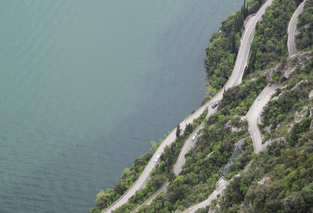 road in mountain slope near body of water