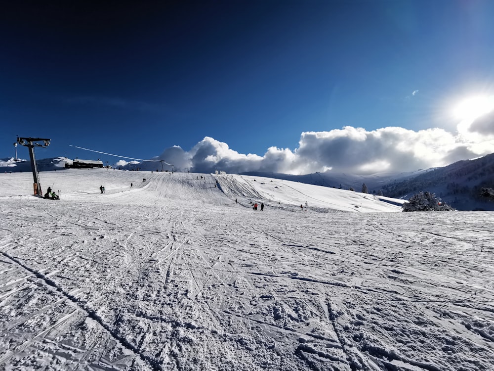 a group of people riding skis down a snow covered slope