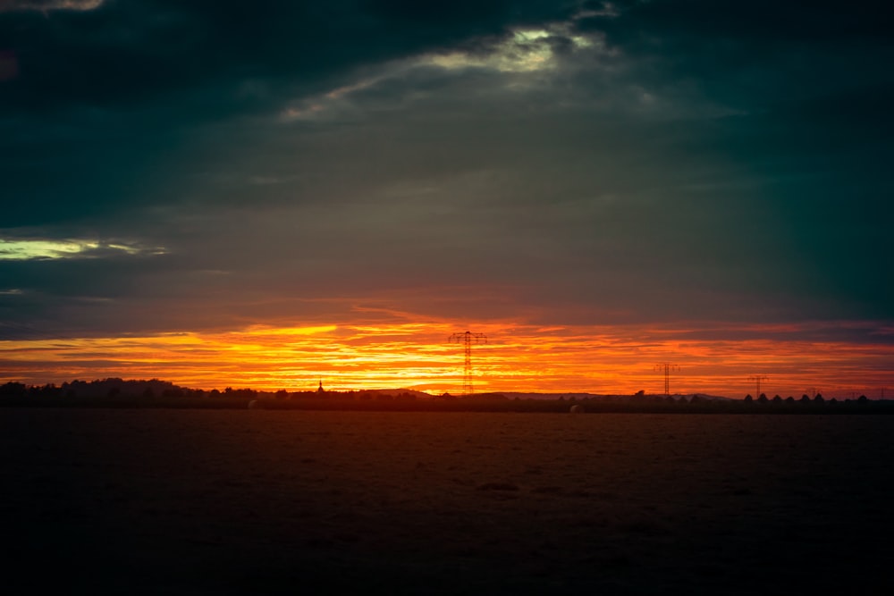 the sun is setting over the horizon of a field