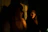 Elegant photo of a woman admiring her reflection wearing a shiny, perfectly styled wig in a warm, softly lit room.