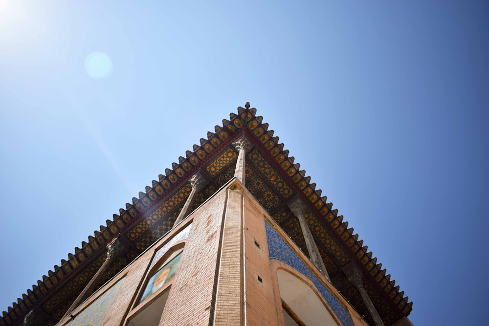 low-angle photography of brown and blue concrete building under clear blue sky