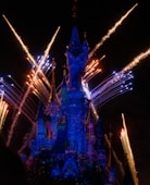 time-lapse photography of fireworks shooting above Disneyland castle