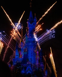 time-lapse photography of fireworks shooting above Disneyland castle