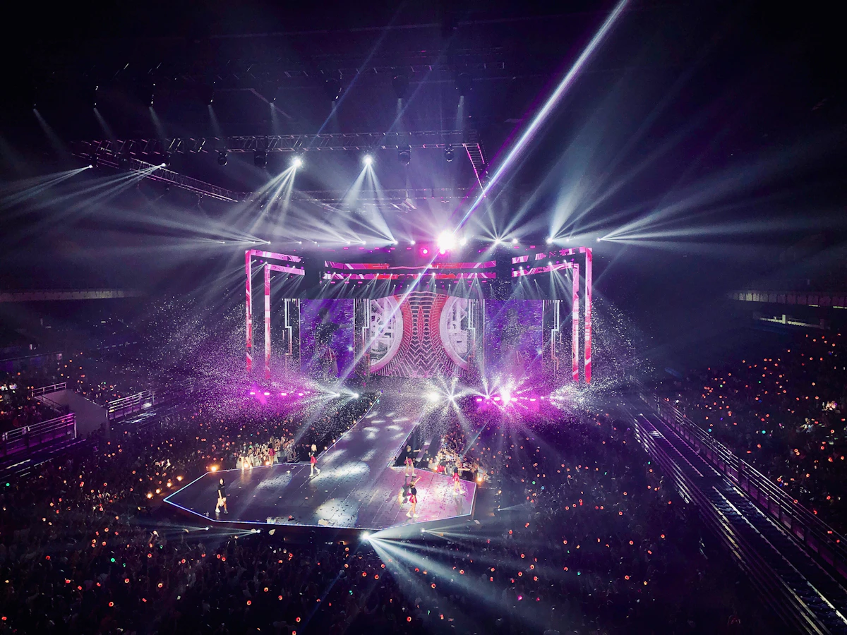 Plateia de show de música com palco iluminado ao fundo