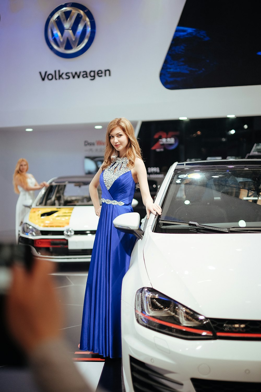 Frau steht neben Volkswagen-Auto