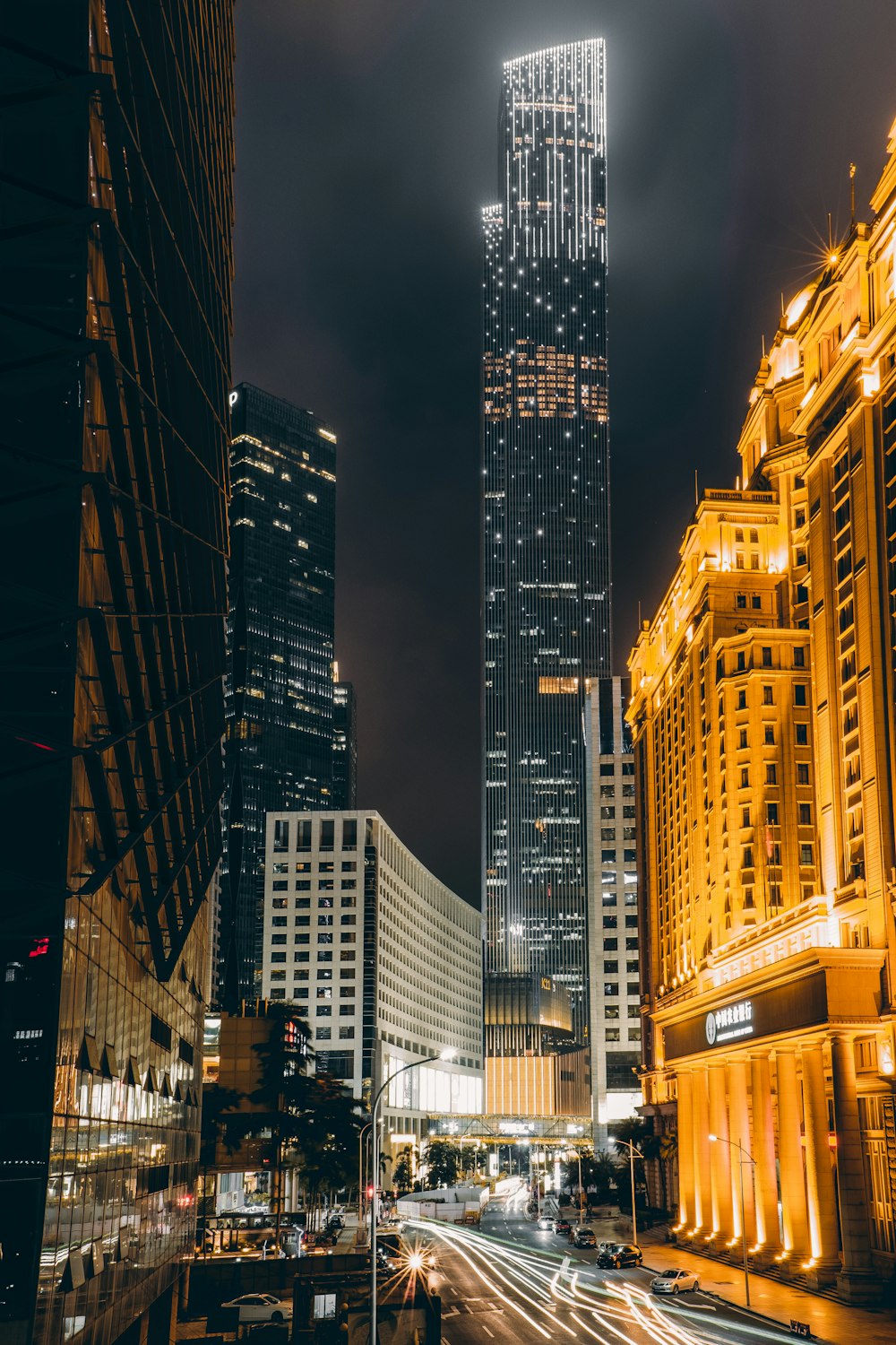 time-lapse photography of road beside high-rise buildings during night
