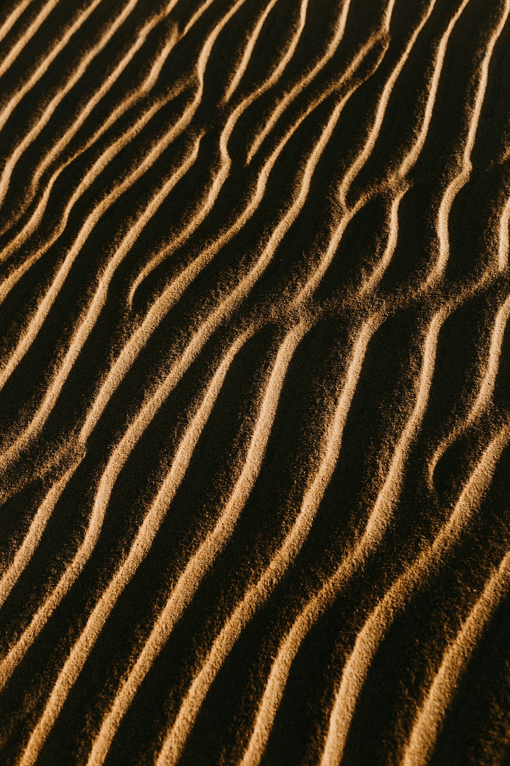 a sand dune with wavy lines in the sand