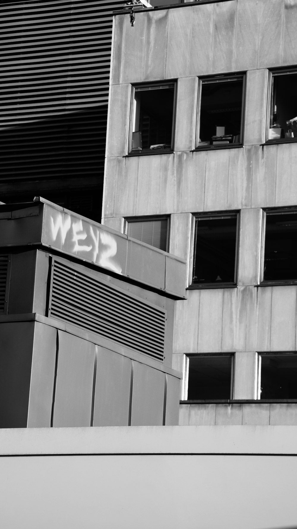 a black and white photo of a building with graffiti on it