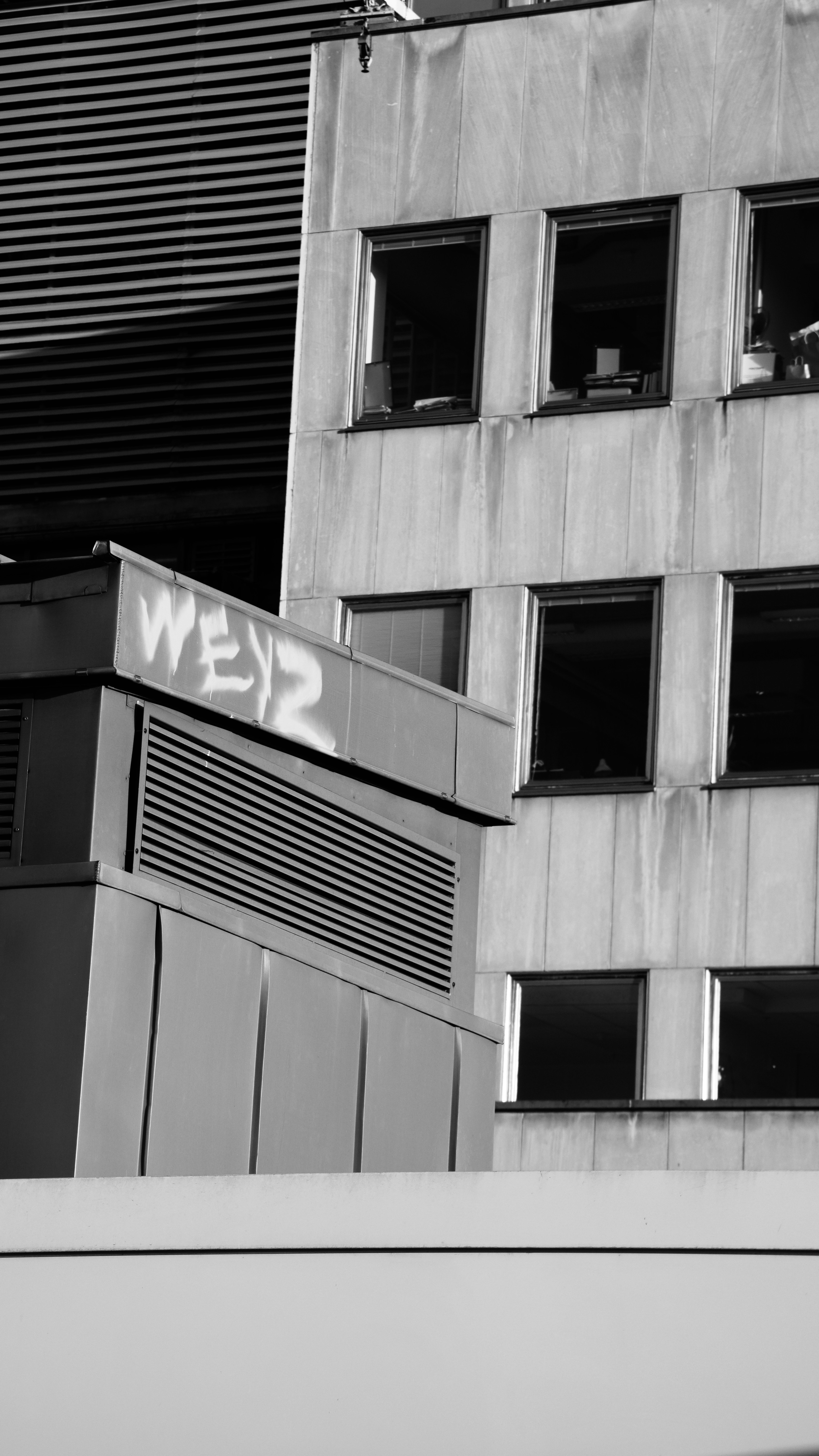 a black and white photo of a building with graffiti on it