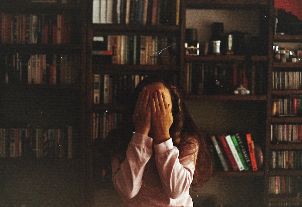 woman covering face on her hand