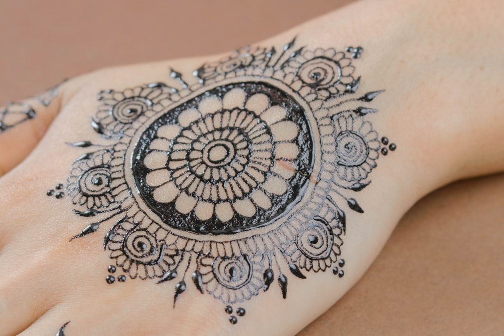 person in black floral mendhi tattoo