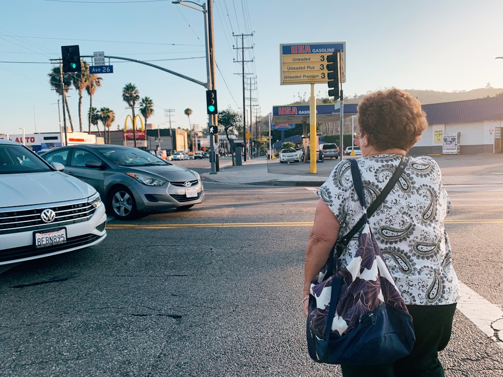 woman standing front of vehicles at daytime