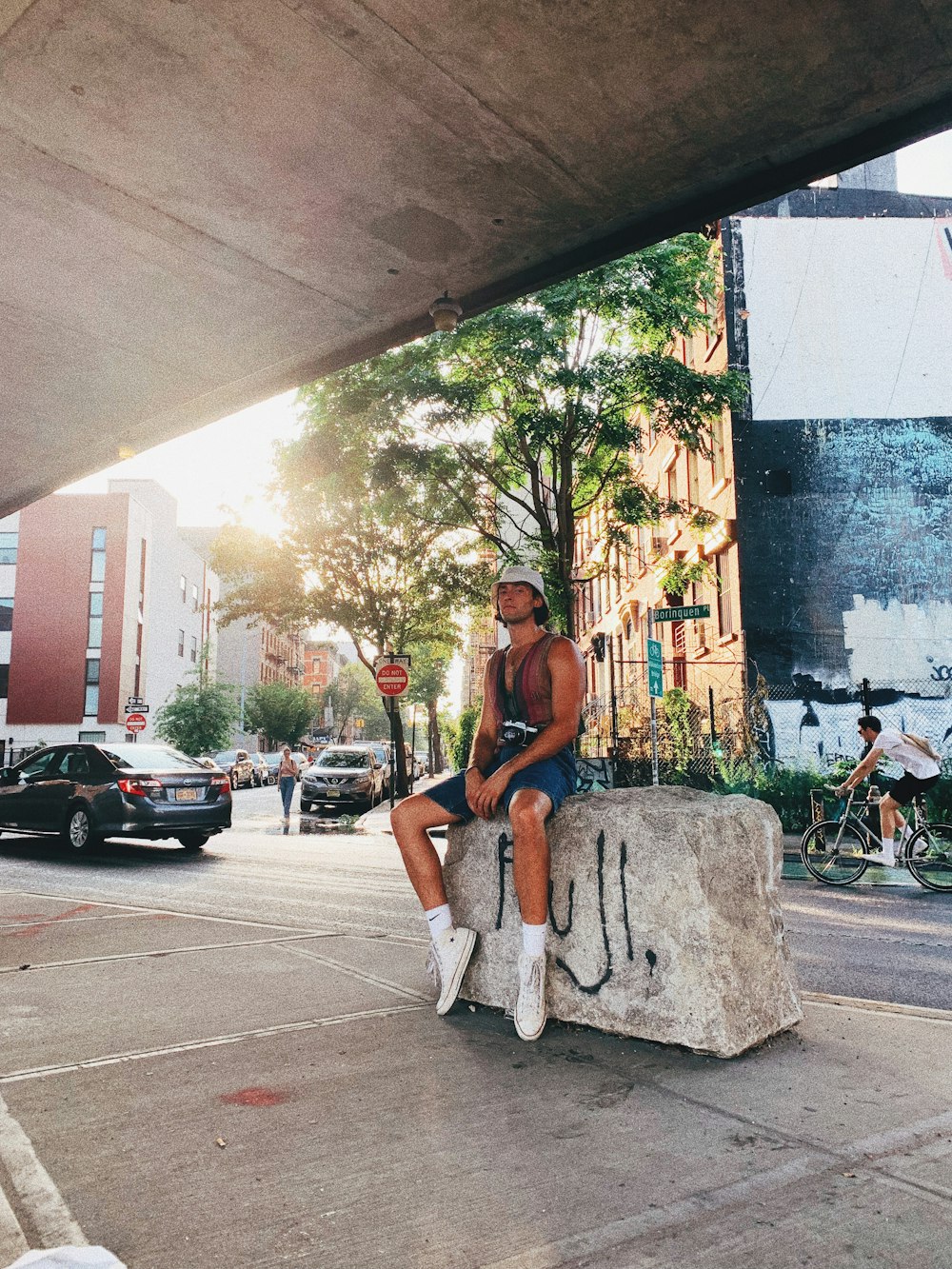 man sitting on concrete seat beside building