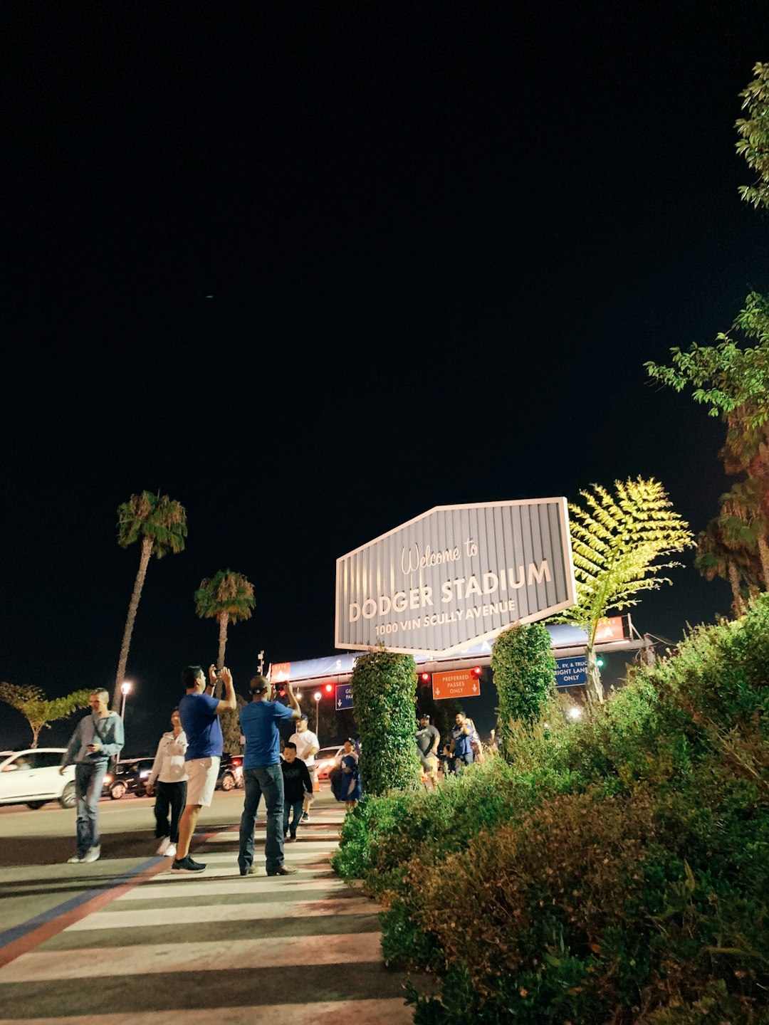 people standing on sidewalk during night time