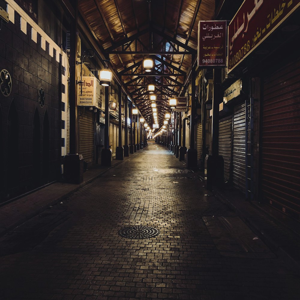 a dark alley way with a clock on the wall