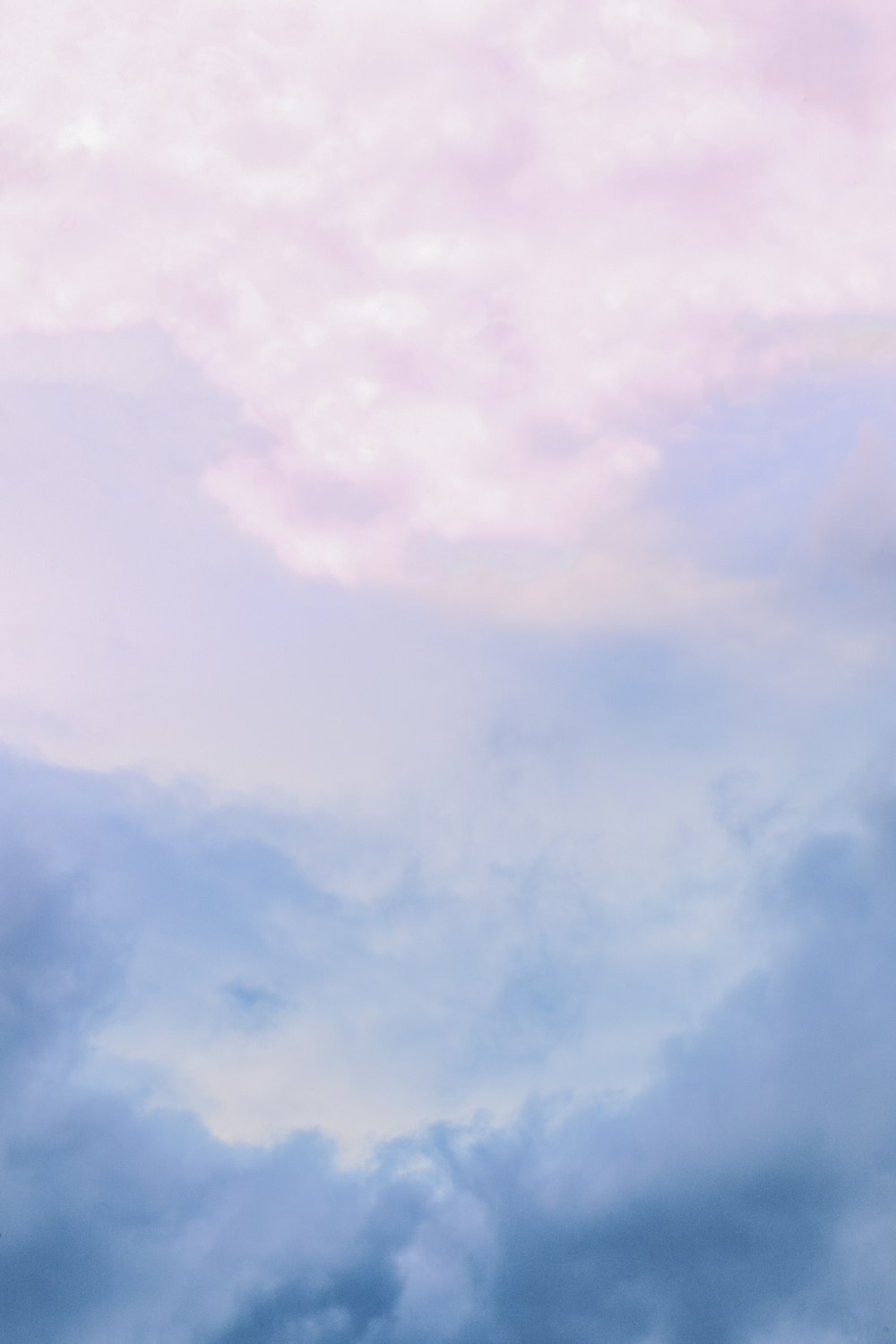 a plane flying through a cloudy blue sky