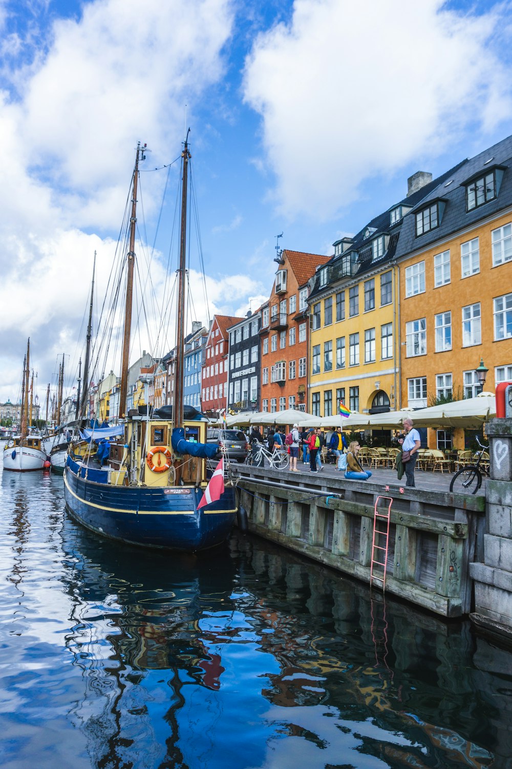 boats beside bay near buildings and people