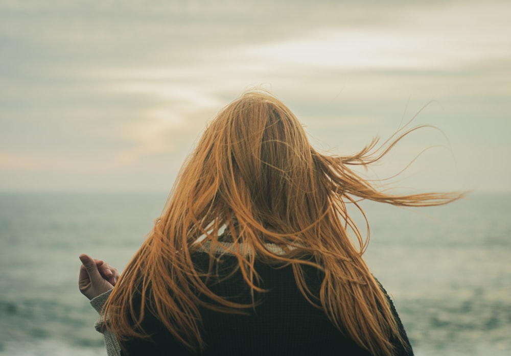 la parte posteriore della testa di una donna mentre si trova sulla spiaggia