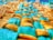 A close-up of a textured fabric with a woven pattern, featuring a combination of yellow and teal colored fibers. The fabric appears soft and plush, with a detailed view of both smooth and textured surfaces.