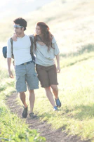 A caregiver and client enjoying a walk together in a sunny neighborhood park.