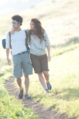 A caregiver and client enjoying a walk together in a sunny garden.