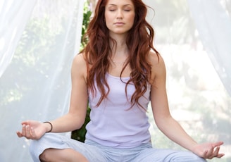 woman doing yoga pose sitting on wooden ground
