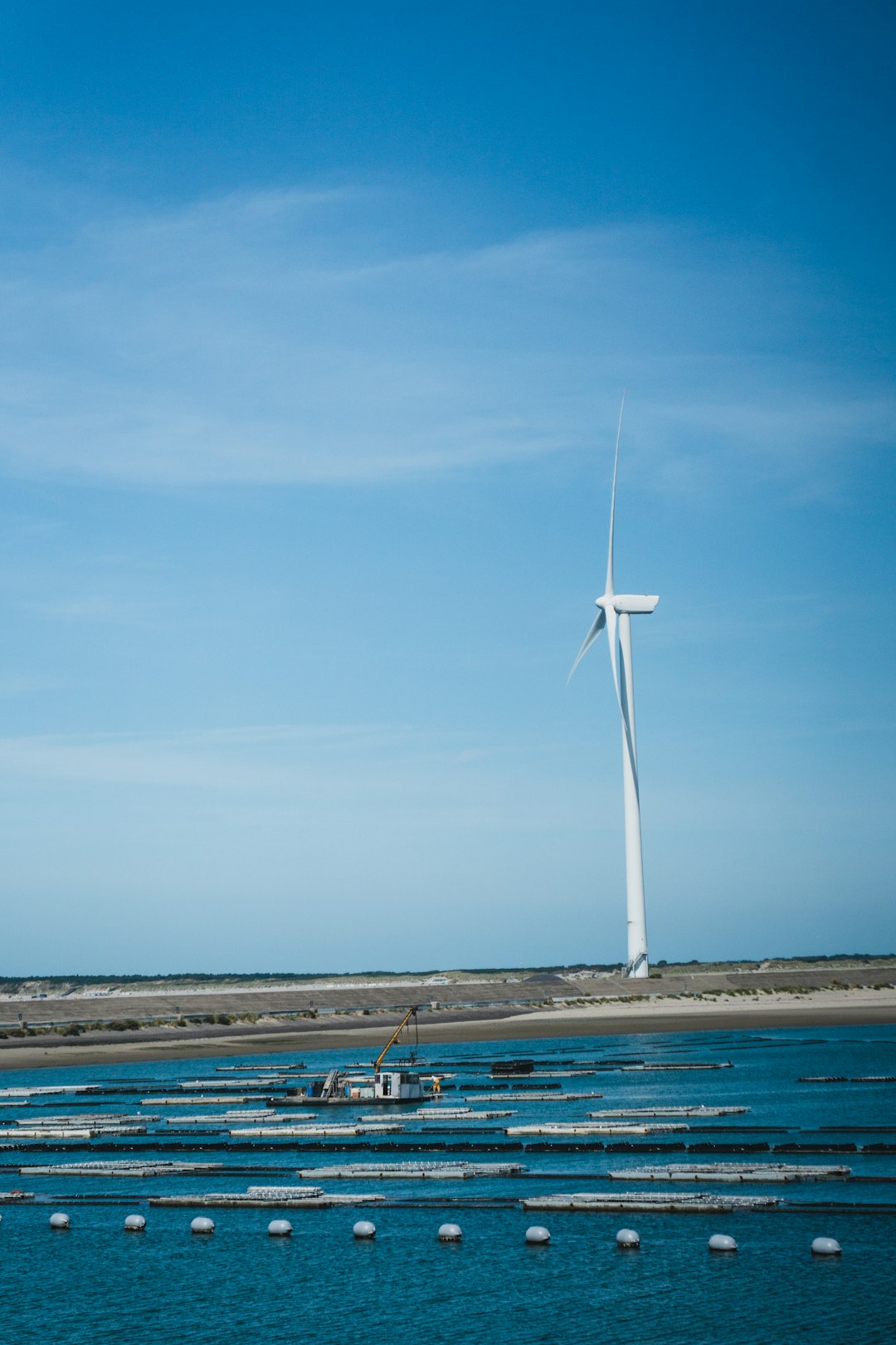 white wind turbine beside sea