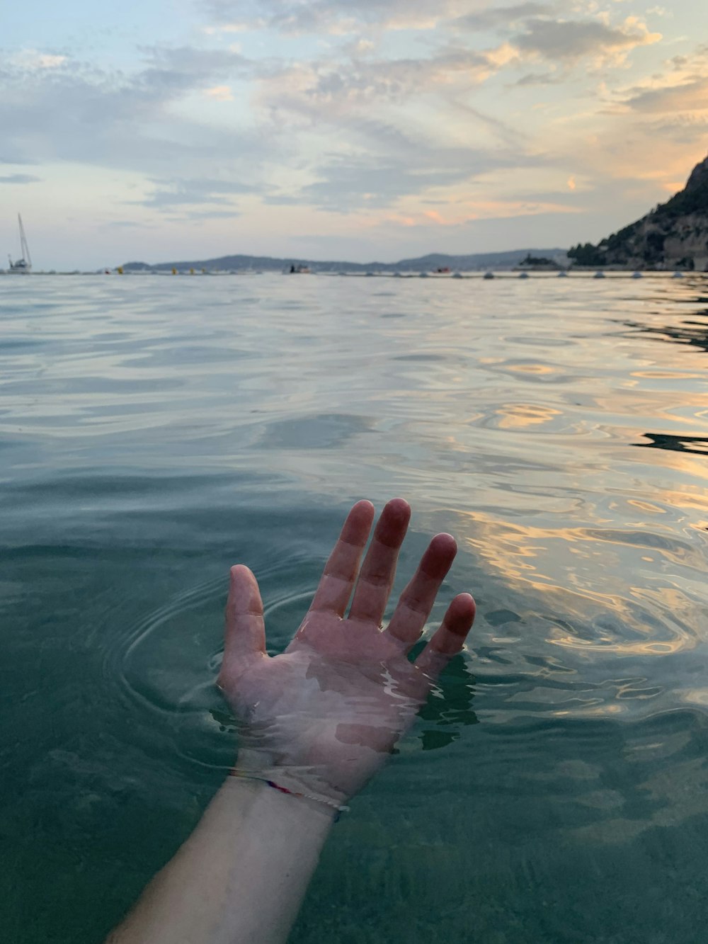 person hand on water at daytime