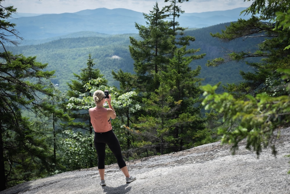 Mujer de pie sobre la roca cerca de los árboles