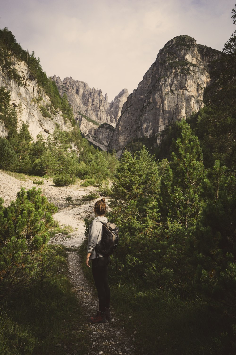 person wearing backpack near mountain during daytime