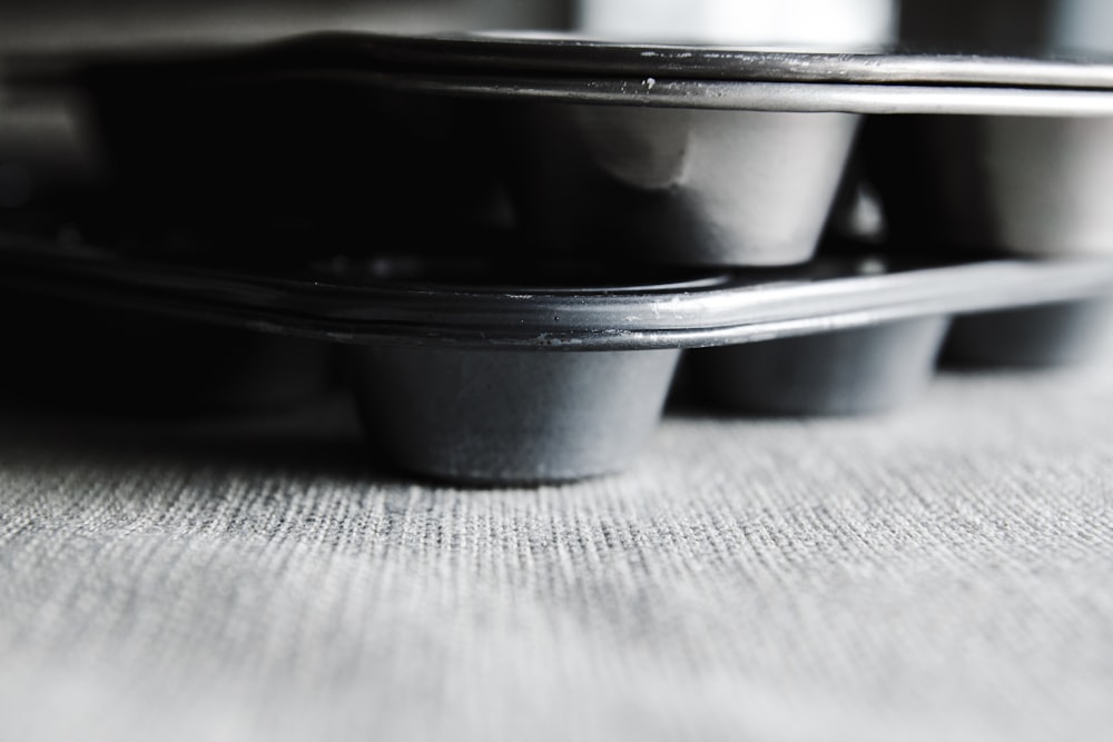 a row of black cups sitting on top of a table